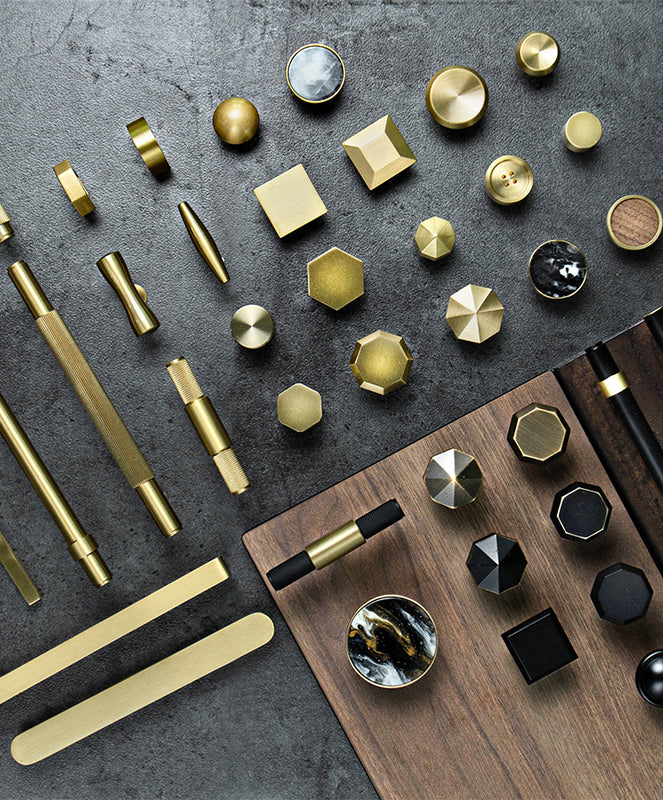 Image of a collection of brass hardware items from UNTOLDstr, including various styles of handles and knobs, all showcasing the rich, golden color and sleek finish of brass.